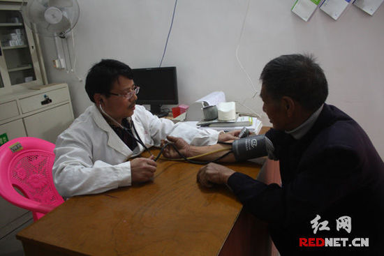 李石清正在给71岁的村民凡冬林量血压。